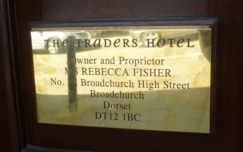 Close up view of a brass plaque that reads Traders Hotel, Owner and Proprietor Rebecca Fisher, for the exterior of the fictional hotel in Broadchurch