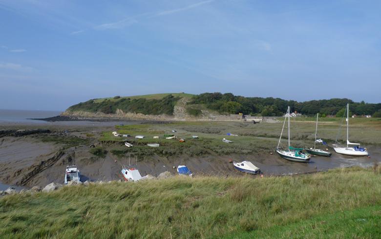 White boats lined up along a sandy bed where the rivers meet at Clevedon