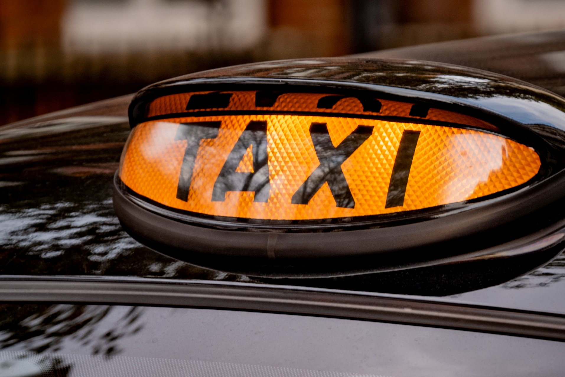 close up of a black cab illuminated taxi sign