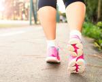 woman wearing pink sports shoes walking