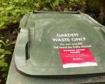 A photo showing a green garden waste bin with a North Somerset Council permit stuck to the lid