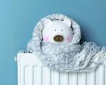piggy bank wrapped in a grey scarf sat on top of a radiator