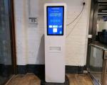 A vending machine for STI and HIV testing kits - tall, white machine with large touchscreen on the front