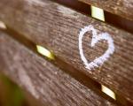 Close up of a white heart painted onto the back of a wooden bench