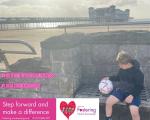 A photo of a young boy holding a football while sitting on a bench on the seafront in Weston-super-Mare.