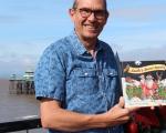 A photo of author and illustrator Steve Gunning holding his book Santa's Secret Agents