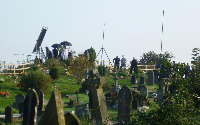 A far away shot in a graveyard of the film crew filming scenes for the ITV series Broadchurch
