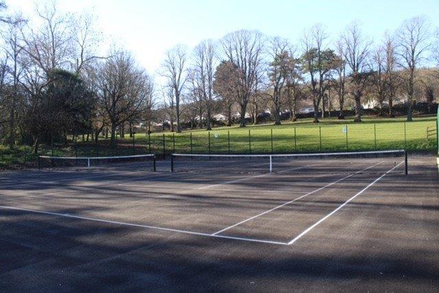 Ashcombe Park tennis courts with tree shadows stretching across the ground