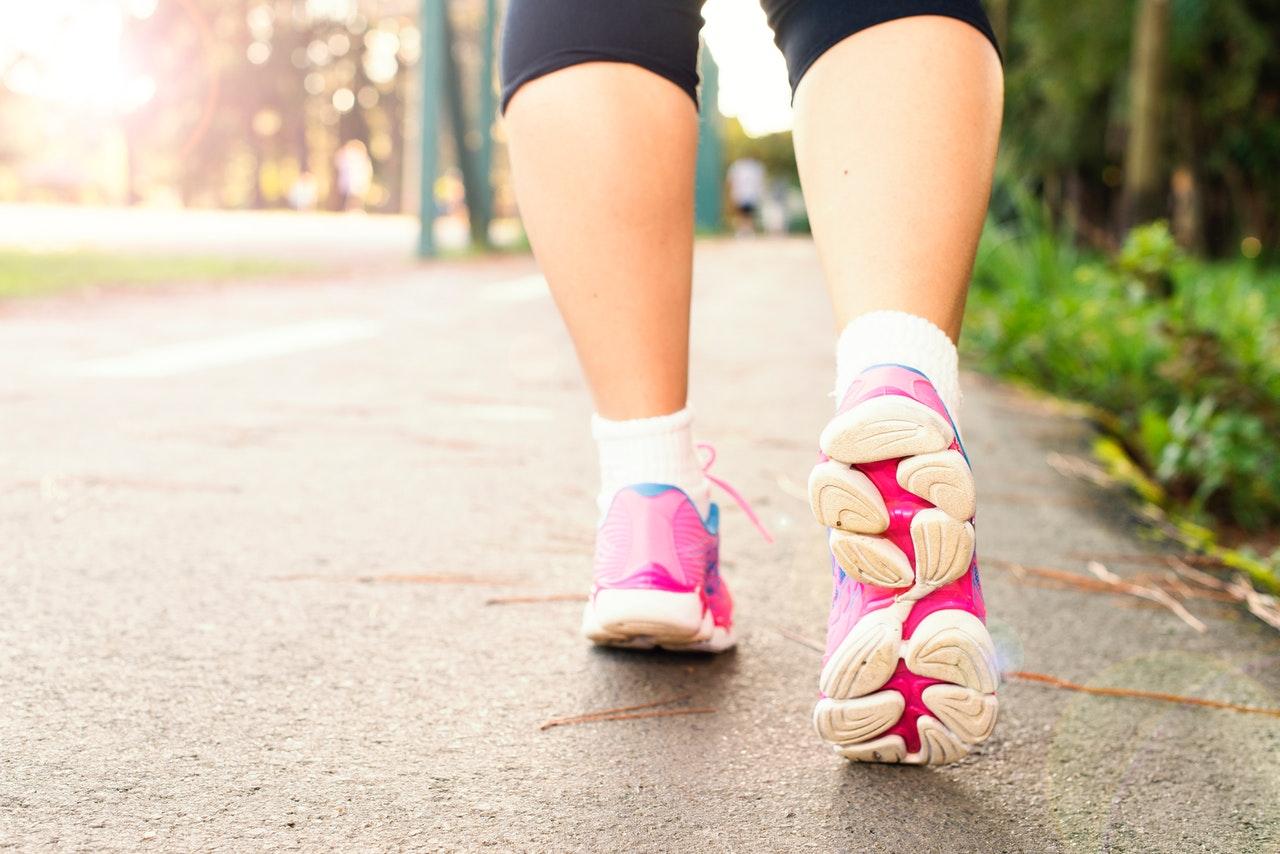 woman wearing pink sports shoes walking