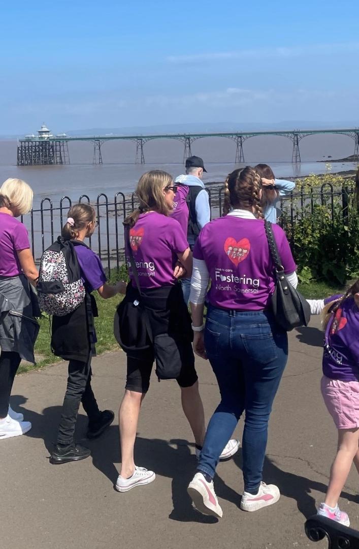 A photo taken of people walking  along Clevedon seafront to mark Foster Care Fortnight 2022