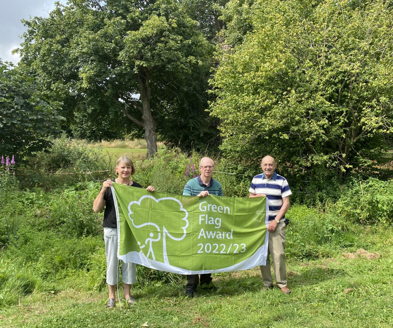A photo of some of the friends of Trendlewood Community Park in Nailsea holding the Green Flag Award 2022/23.