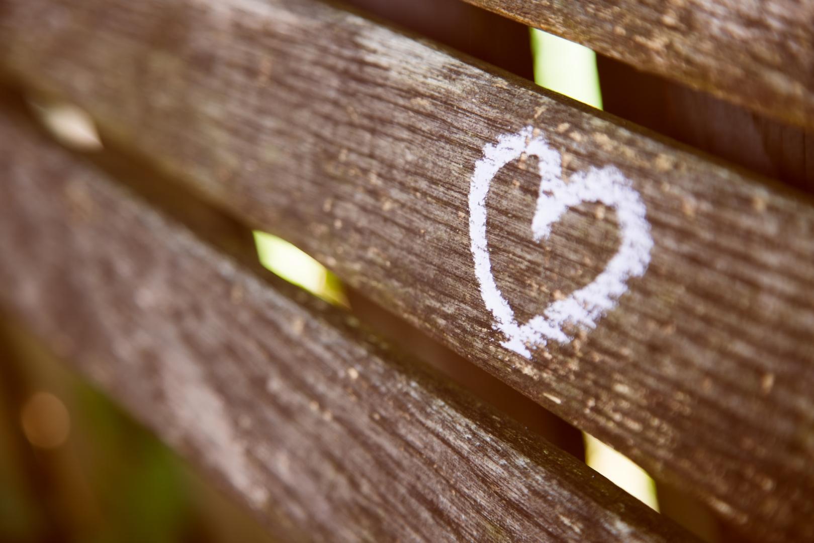 Close up of a white heart painted onto the back of a wooden bench