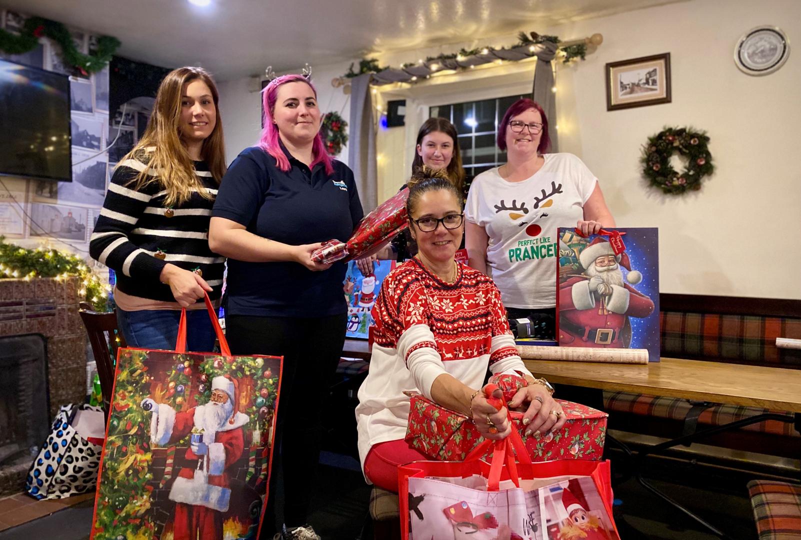 Volunteers at The Lamb Inn, Worle. Pictured from left to right: Keeley Vowels; Laura Hughes; Charley Hughes; Joanne Hughes (standing); and Mandi Dexter (seated) holding Christmas presents for people who are homeless or threatened with homelessness