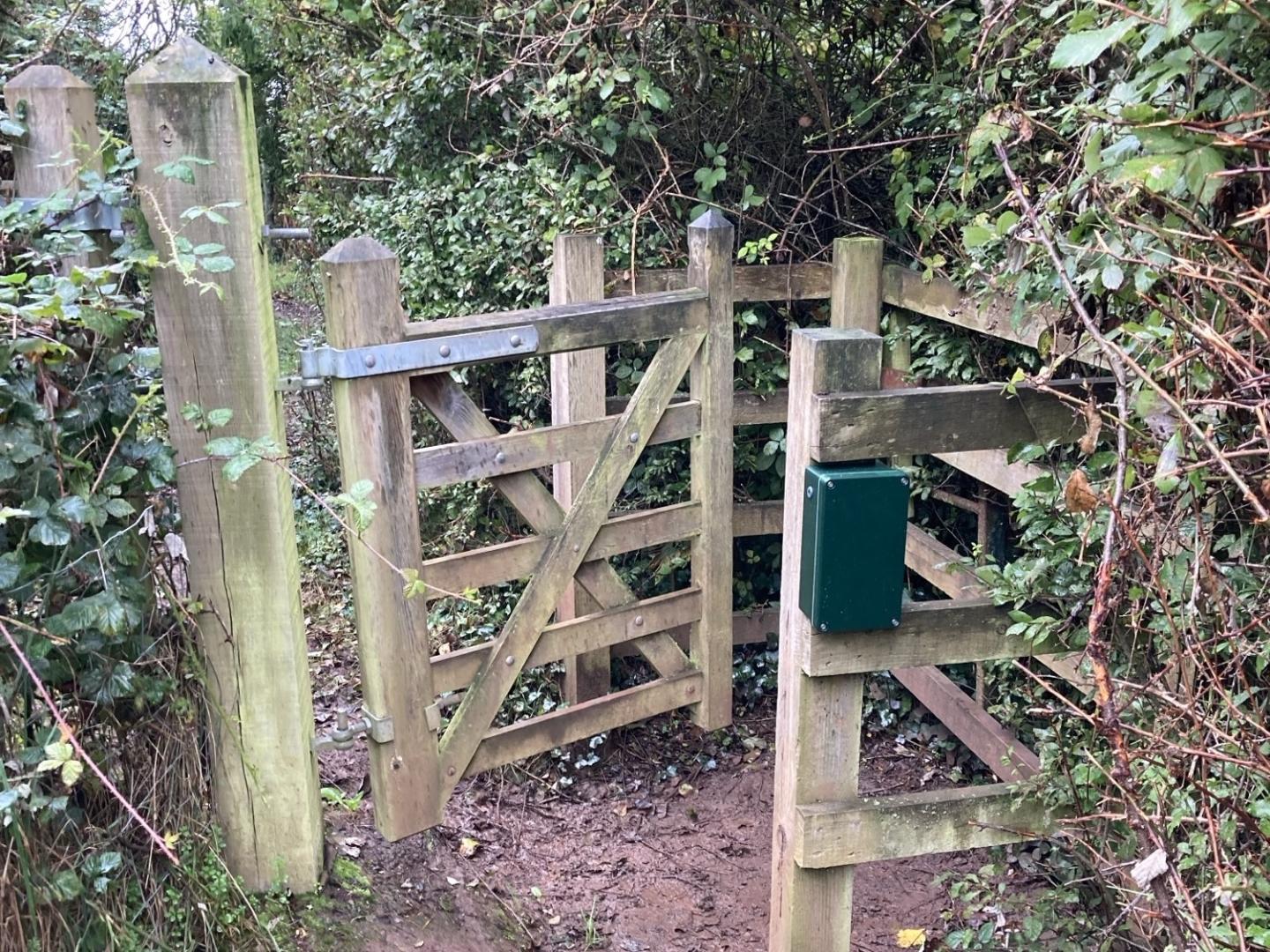 A photograph of a gate on a Public Rights of Way with a green box fixed to the post